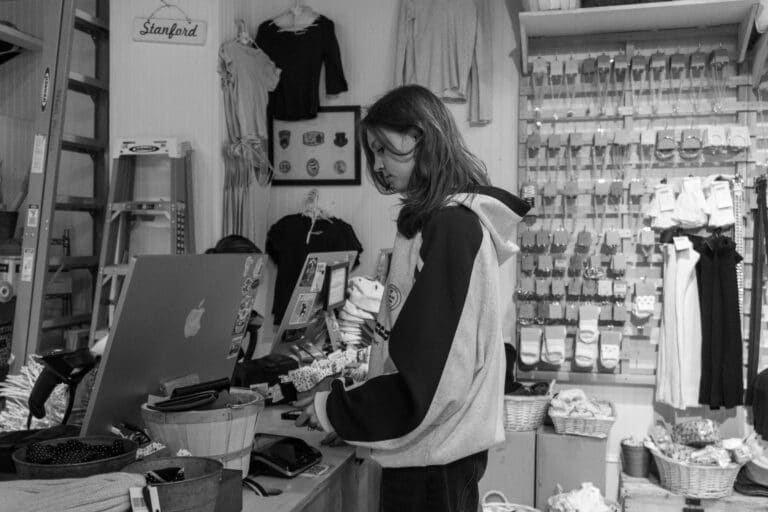 Dueña de una tienda atendiendo en el mostrador de su negocio local